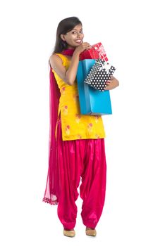 A beautiful woman posing with a shopping bag and gift Boxes on a white background.