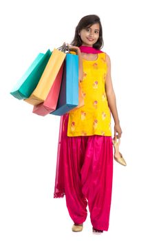 Beautiful Indian young girl holding and posing with shopping bags on a white background