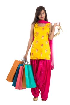 Beautiful Indian young girl holding and posing with shopping bags on a white background