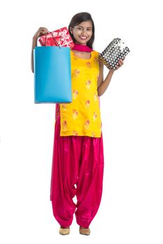 A beautiful woman posing with a shopping bag and gift Boxes on a white background.