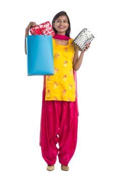 A beautiful woman posing with a shopping bag and gift Boxes on a white background.