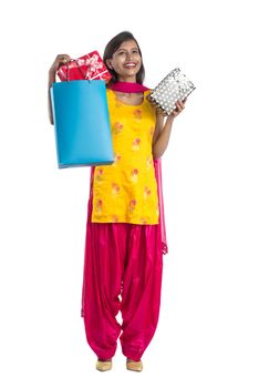 A beautiful woman posing with a shopping bag and gift Boxes on a white background.