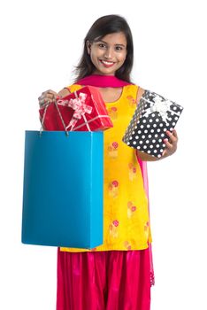 A beautiful woman posing with a shopping bag and gift Boxes on a white background.