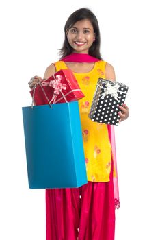 A beautiful woman posing with a shopping bag and gift Boxes on a white background.