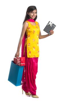 A beautiful woman posing with a shopping bag and gift Boxes on a white background.