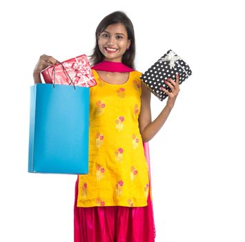 A beautiful woman posing with a shopping bag and gift Boxes on a white background.