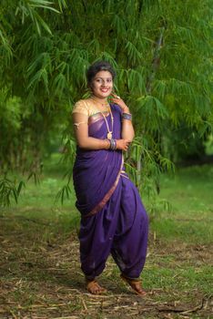 Indian Beautiful young girl in Traditional Saree posing outdoors