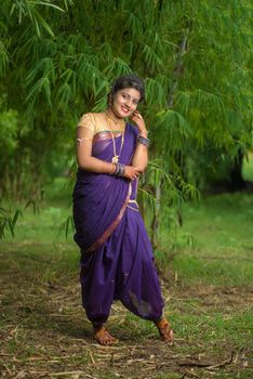 Indian Beautiful young girl in Traditional Saree posing outdoors