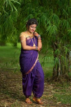 Indian Beautiful young girl in Traditional Saree posing outdoors