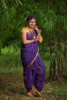 Indian Beautiful young girl in Traditional Saree posing outdoors