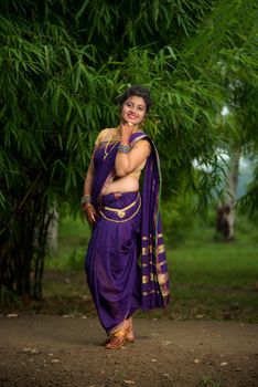 Indian Beautiful young girl in Traditional Saree posing outdoors