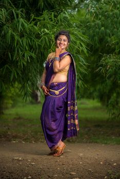 Indian Beautiful young girl in Traditional Saree posing outdoors