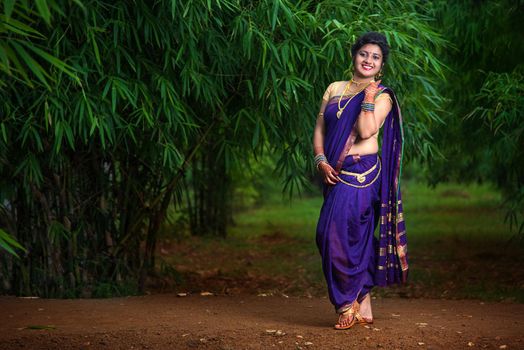 Indian Beautiful young girl in Traditional Saree posing outdoors