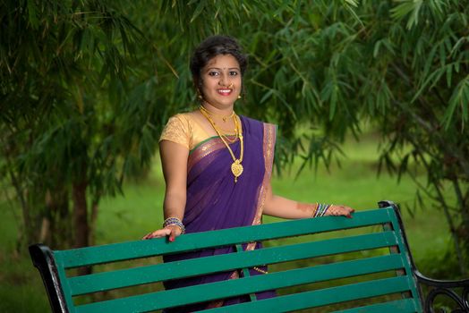 Beautiful Indian young girl in Traditional Saree posing outdoors