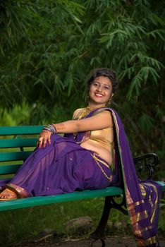 Beautiful Indian young girl in Traditional Saree posing outdoors