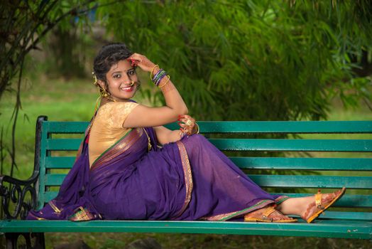 Beautiful Indian young girl in Traditional Saree posing outdoors