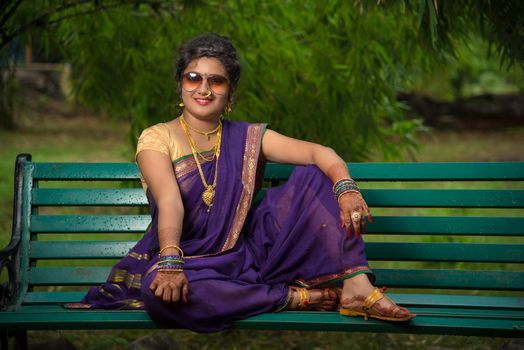 Beautiful Indian young girl in Traditional Saree posing outdoors