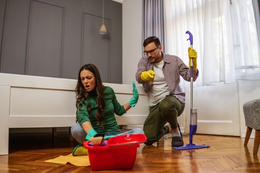 Woman is lazy. Man is telling her to continue cleaning their apartment.