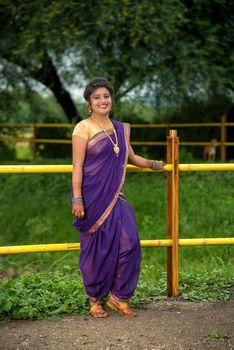 Beautiful Indian young girl in Traditional Saree posing outdoors