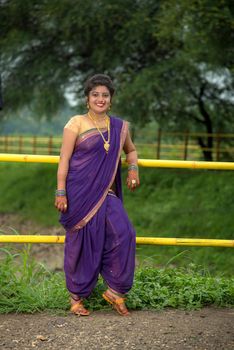 Beautiful Indian young girl in Traditional Saree posing outdoors