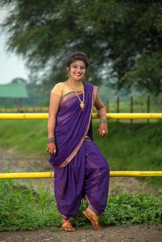 Beautiful Indian young girl in Traditional Saree posing outdoors