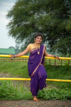 Beautiful Indian young girl in Traditional Saree posing outdoors