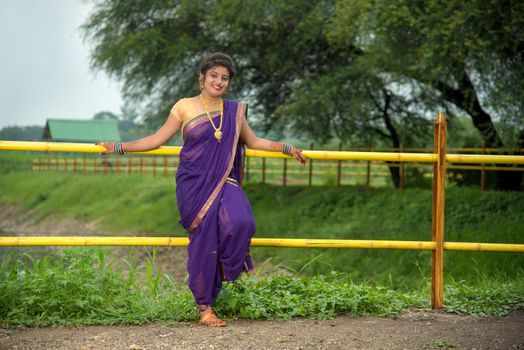 Beautiful Indian young girl in Traditional Saree posing outdoors