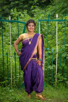 Beautiful Indian young girl in Traditional Saree posing outdoors