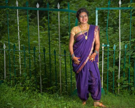 Beautiful Indian young girl in Traditional Saree posing outdoors