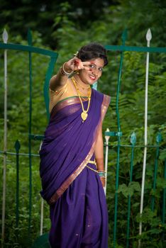 Beautiful Indian young girl in Traditional Saree posing outdoors