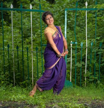 Beautiful Indian young girl in Traditional Saree posing outdoors