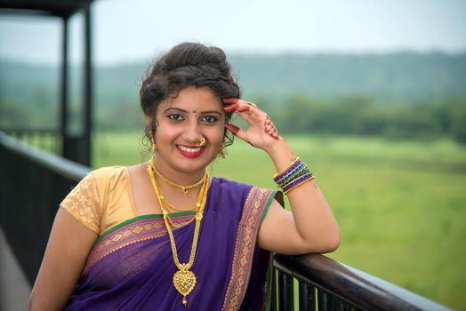 Beautiful Indian young girl in Traditional Saree posing outdoors