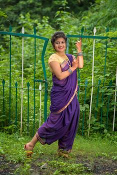 Beautiful Indian young girl in Traditional Saree posing outdoors