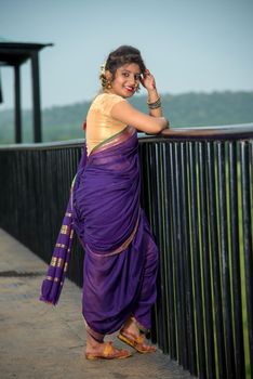 Beautiful Indian young girl in Traditional Saree posing outdoors