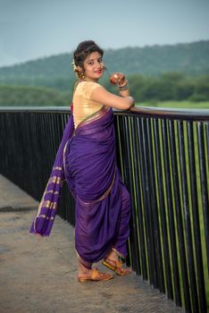 Beautiful Indian young girl in Traditional Saree posing outdoors