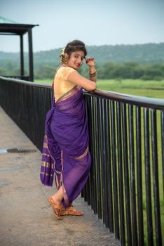 Beautiful Indian young girl in Traditional Saree posing outdoors