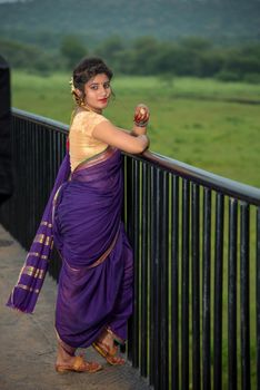 Beautiful Indian young girl in Traditional Saree posing outdoors