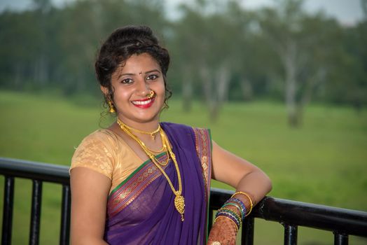 Beautiful Indian young girl in Traditional Saree posing outdoors