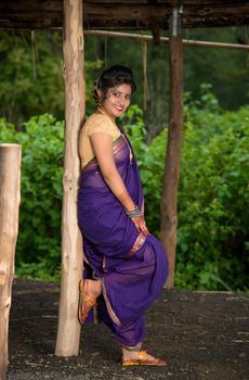 Beautiful Indian young girl in Traditional Saree posing outdoors