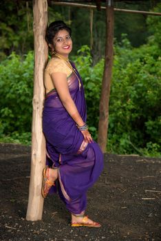 Beautiful Indian young girl in Traditional Saree posing outdoors