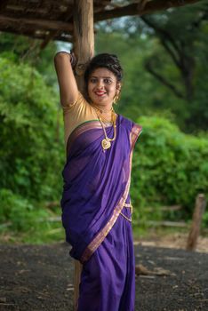 Beautiful Indian young girl in Traditional Saree posing outdoors
