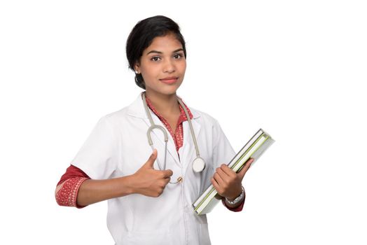 Young woman doctor holding book with stethoscope
