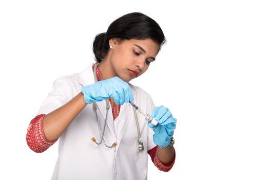 A female doctor with a stethoscope is holding an Injection or Syringe.