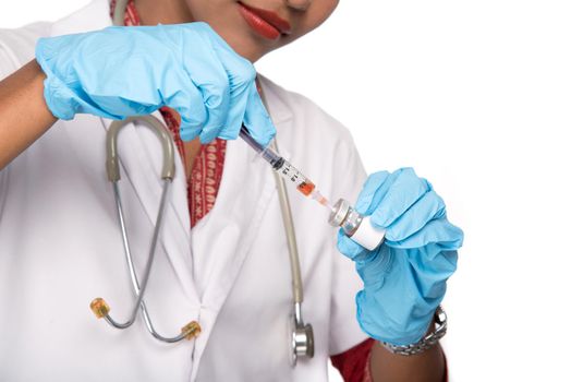 A female doctor with a stethoscope is holding an Injection or Syringe.