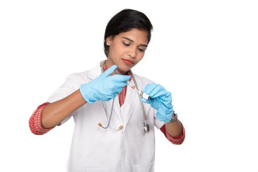 A female doctor with a stethoscope is holding an Injection or Syringe.