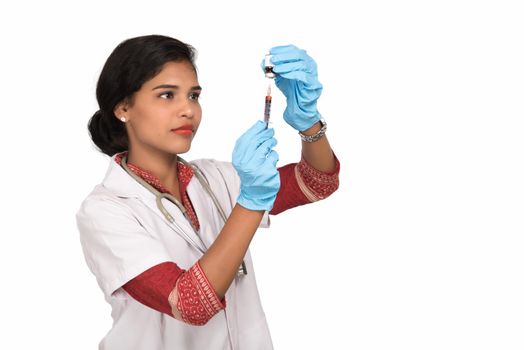 A female doctor with a stethoscope is holding an Injection or Syringe.