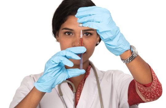 A female doctor with a stethoscope is holding an Injection or Syringe.