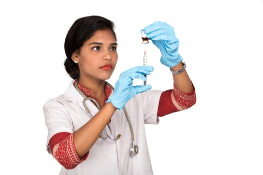 A female doctor with a stethoscope is holding an Injection or Syringe.