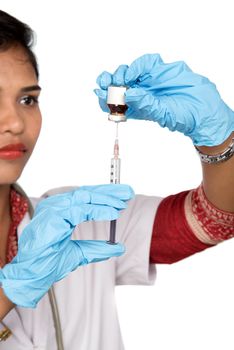 A female doctor with a stethoscope is holding an Injection or Syringe.