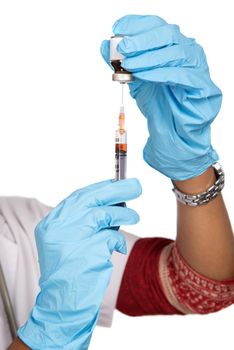 A female doctor with a stethoscope is holding an Injection or Syringe.